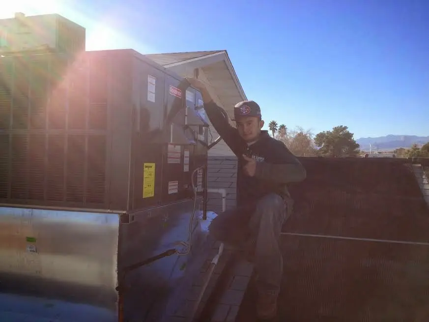 HVAC technician performing Heat Pump Repair on a rooftop unit in Chatham